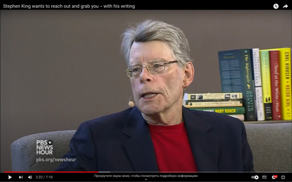 Stephen King gives an interview with books in the background